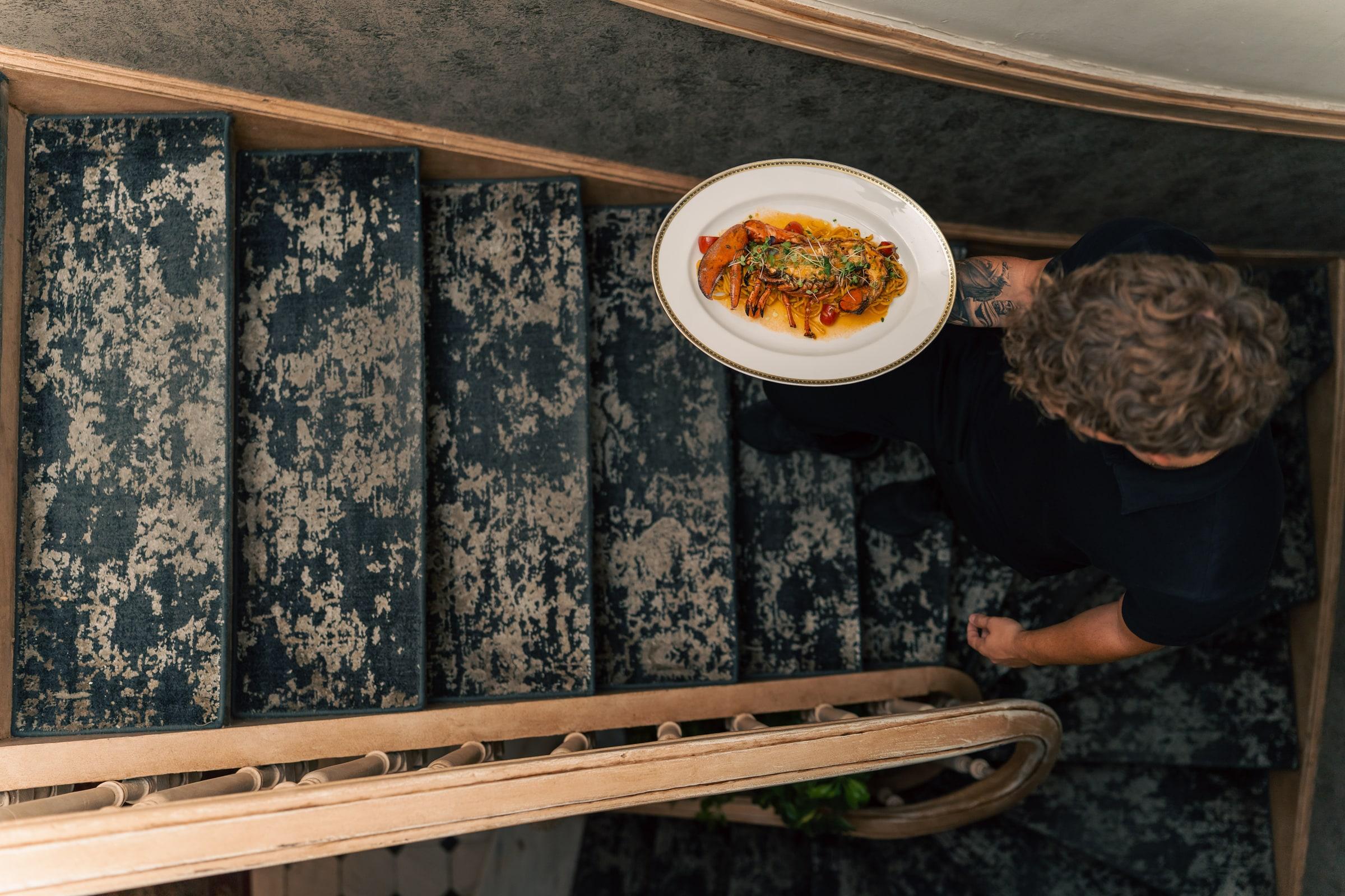 Lobster pasta carried up the staircase to the dining room