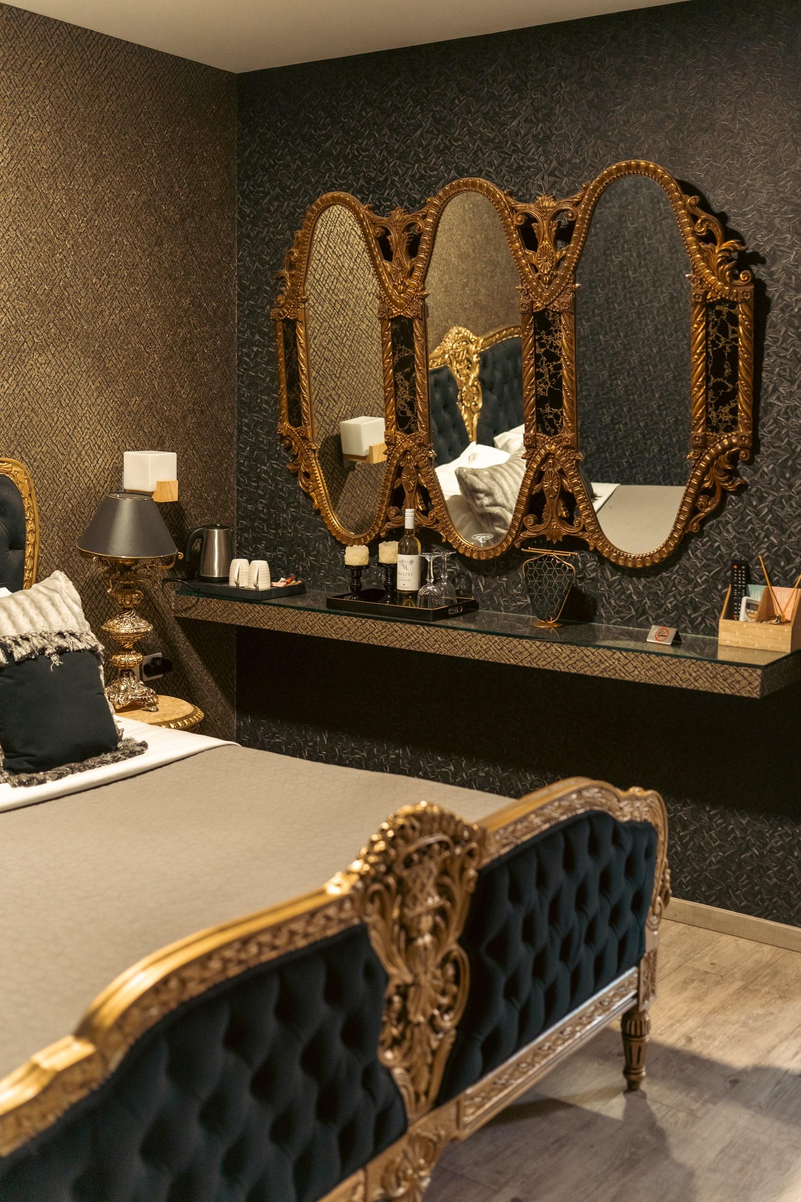 Suite in gold and black with baroque bed and triple mirror